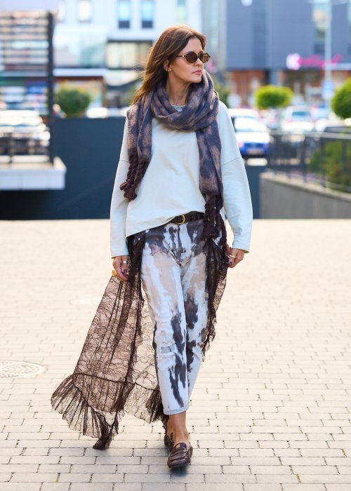 Miękki szal z motywem panterki, zakończony grubymi, plecionymi frędzlami.