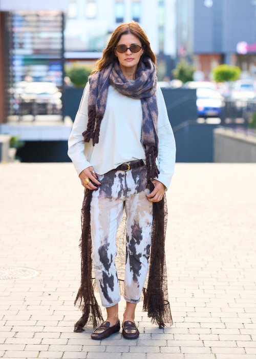 Miękki szal z motywem panterki, zakończony grubymi, plecionymi frędzlami.