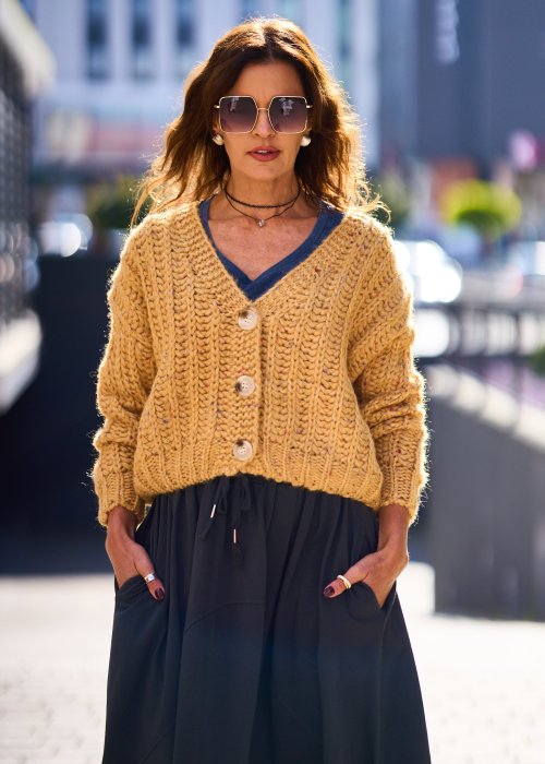 Żółty kardigan damski z grubym splotem, zapinany na duże guziki, o krótszym kroju i luźnym fasonie, styl casual boho