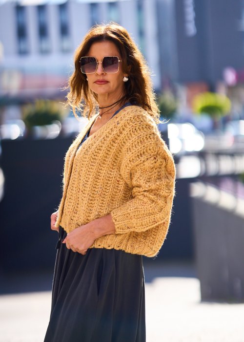 Żółty kardigan damski z grubym splotem, zapinany na duże guziki, o krótszym kroju i luźnym fasonie, styl casual boho