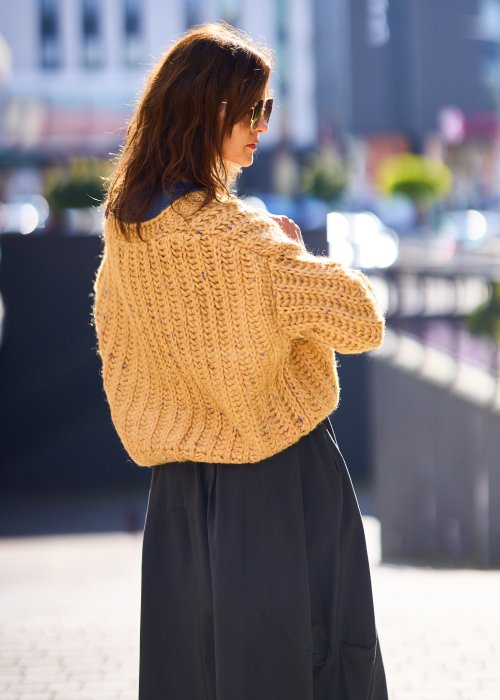 Żółty kardigan damski z grubym splotem, zapinany na duże guziki, o krótszym kroju i luźnym fasonie, styl casual boho