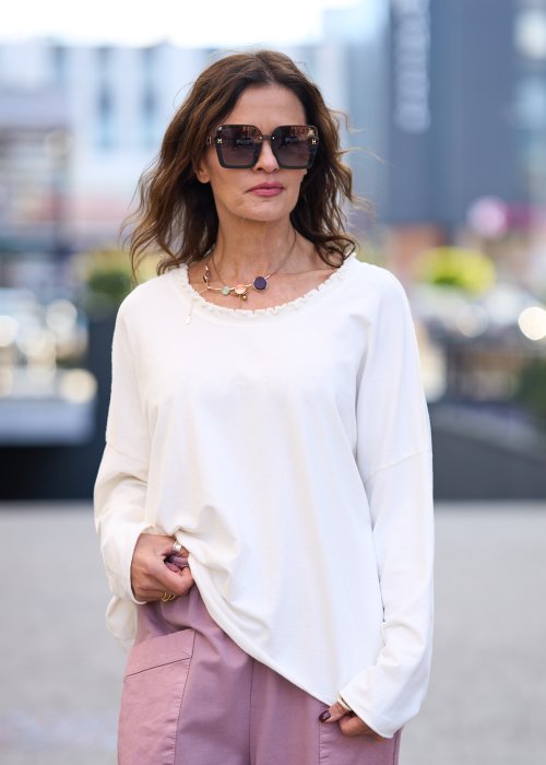 Biała bluzka damska z długim rękawem i delikatnym wykończeniem dekoltu w stylu casual oversize