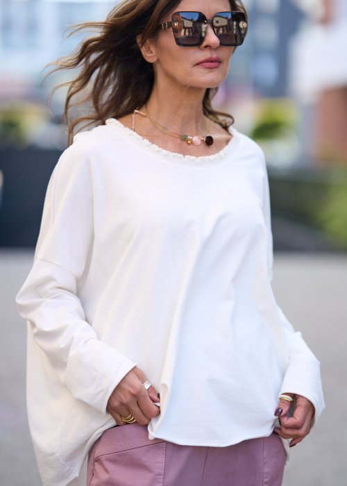 Biała bluzka damska z długim rękawem i delikatnym wykończeniem dekoltu w stylu casual oversize