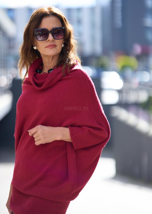 Sweter oversize w kolorze bordowym z szerokim kołnierzem typu komin i luźnym krojem poncza. Model w miejskiej stylizacji podkreślający miękką dzianinę i swobodny fason.