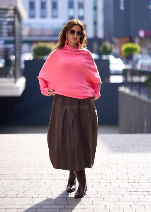 Jasnoróżowy sweter damski oversize o nietoperzowym kroju z asymetrycznym dołem, stylizacja miejska ze spódnicą.