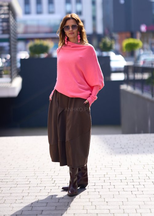 Jasnoróżowy sweter damski oversize o nietoperzowym kroju z asymetrycznym dołem, stylizacja miejska ze spódnicą.