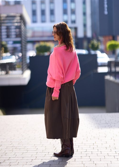 Jasnoróżowy sweter damski oversize o nietoperzowym kroju z asymetrycznym dołem, stylizacja miejska ze spódnicą.