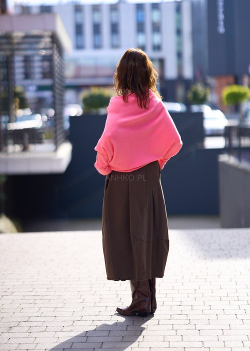 Jasnoróżowy sweter damski oversize o nietoperzowym kroju z asymetrycznym dołem, stylizacja miejska ze spódnicą.