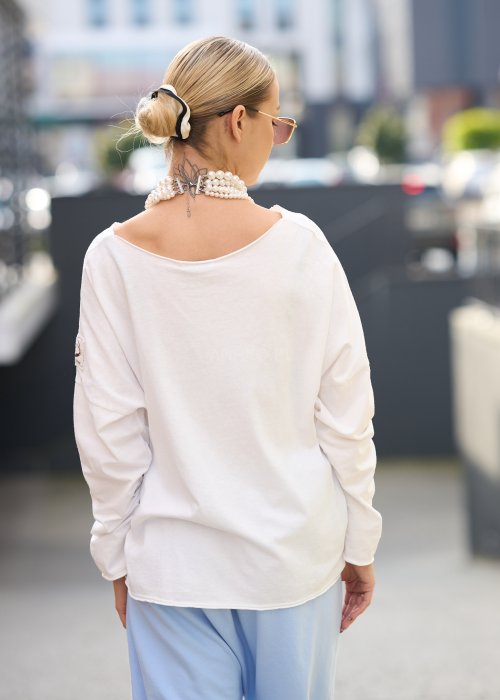 luźną, białą bluzkę o oversize’owym kroju