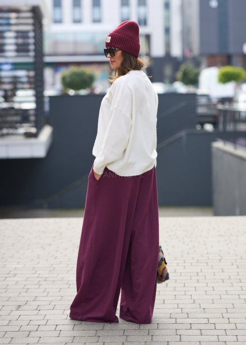 Śliwkowe spodnie damskie o szerokich nogawkach z elastyczną talią, luźny fason w nowoczesnej stylizacji miejskiej.