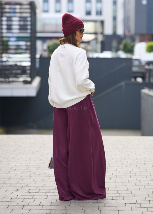 Śliwkowe spodnie damskie o szerokich nogawkach z elastyczną talią, luźny fason w nowoczesnej stylizacji miejskiej.