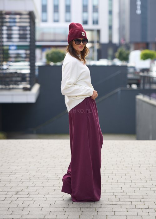 Śliwkowe spodnie damskie o szerokich nogawkach z elastyczną talią, luźny fason w nowoczesnej stylizacji miejskiej.