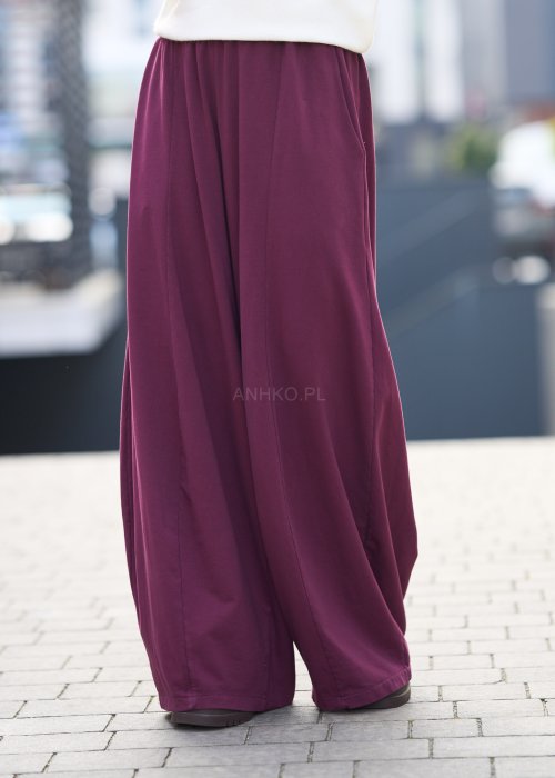 Śliwkowe spodnie damskie o szerokich nogawkach z elastyczną talią, luźny fason w nowoczesnej stylizacji miejskiej.