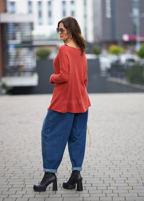 Niebieskie jeansy damskie o kroju slouchy z elastycznym pasem i podwiniętą nogawką. Stylizacja z botkami na obcasie w miejskim, casualowym stylu.