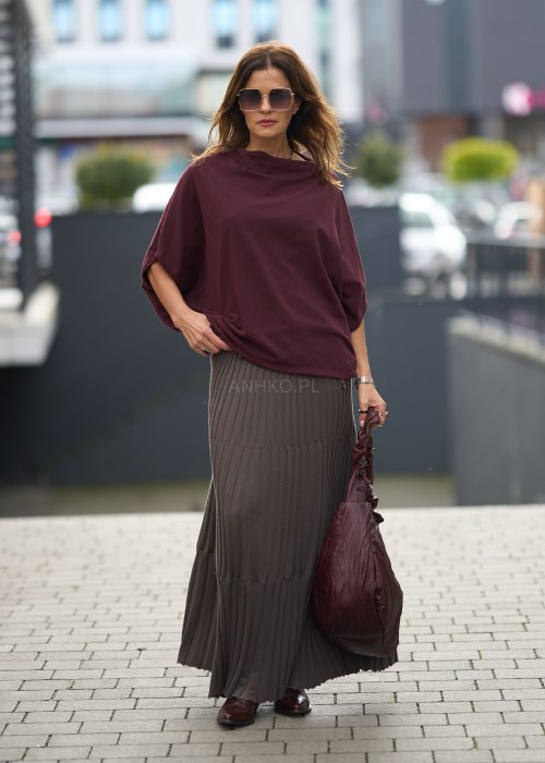 Śliwkowa bluzka damska oversize z rękawami typu nietoperz i szerokim dekoltem, zestawiona ze spódnicą w eleganckiej miejskiej stylizacji.