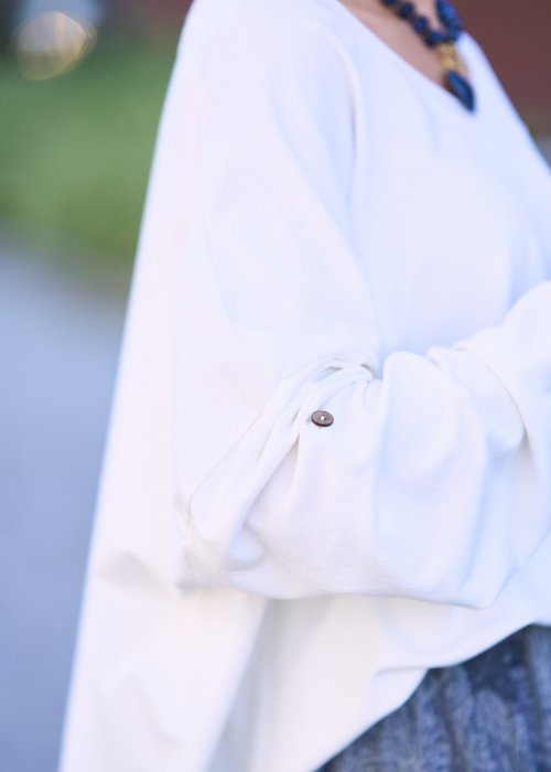 Biała bluzka oversize z dekoltem w serek i długim rękawem, lekka stylizacja w modzie damskiej