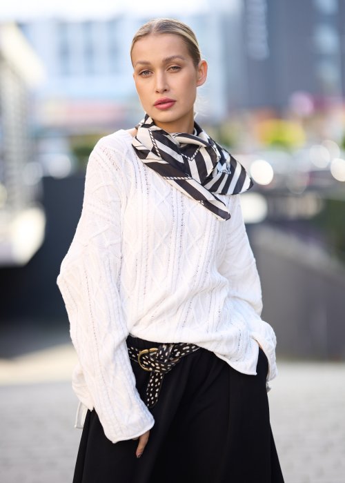Biały sweter o grubym splocie z luźnym fasonem oversize, elegancka stylizacja damska