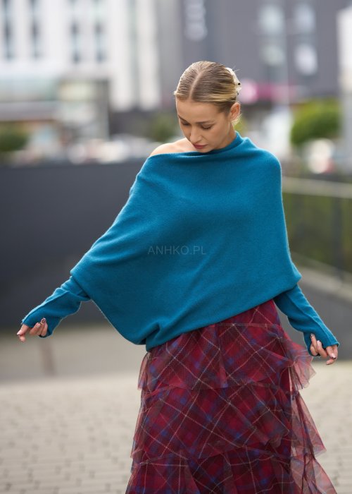 Morski sweter damski oversize o nietoperzowym kroju z asymetrycznym dołem, stylizacja miejska ze spódnicą w kratę.