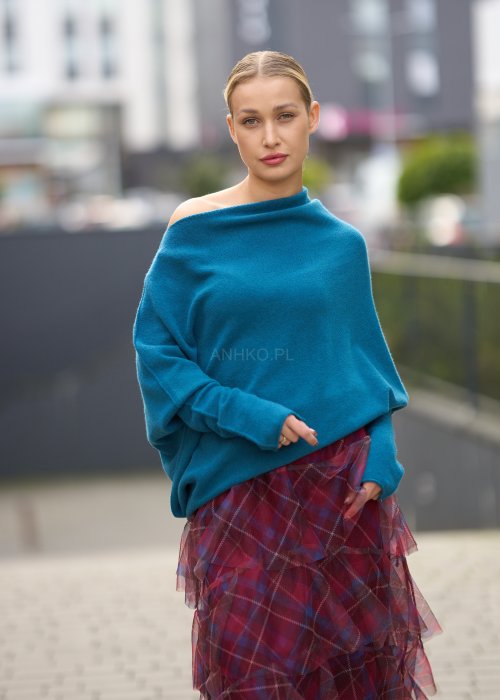 Morski sweter damski oversize o nietoperzowym kroju z asymetrycznym dołem, stylizacja miejska ze spódnicą w kratę.