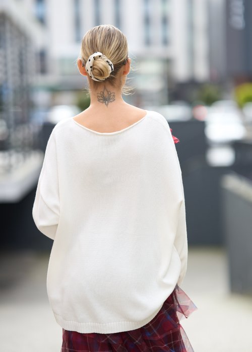 Śmietankowy sweter z miękkiej dzianiny o luźnym kroju oversize i obniżonej linii ramion, w stylu minimalistycznym