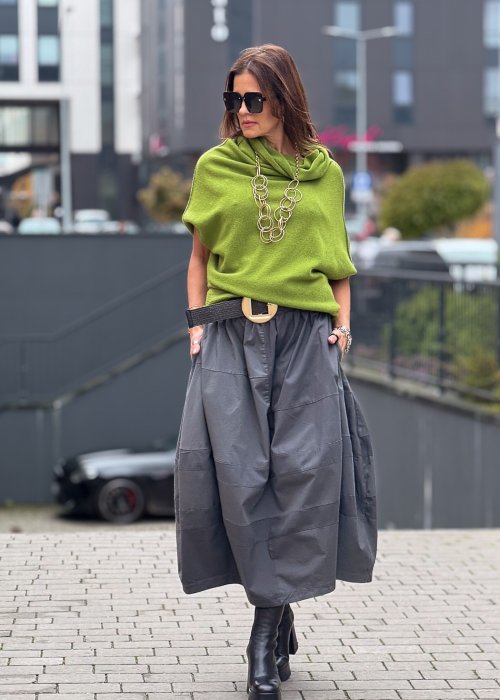Grafitowa spódnica damska o kroju bombki z kieszeniami i dekoracyjnymi przeszyciami, pokazana w stylizacji z zielonym swetrem i czarnymi botkami na obcasie.