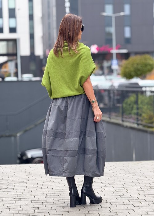 Grafitowa spódnica damska o kroju bombki z kieszeniami i dekoracyjnymi przeszyciami, pokazana w stylizacji z zielonym swetrem i czarnymi botkami na obcasie.
