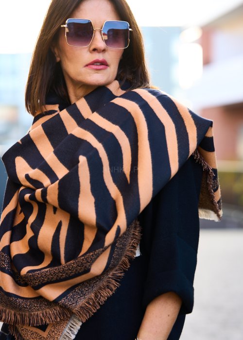 owinięta beżowo-czarną chustą z geometrycznym wzorem