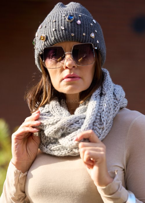 szarej czapce z dużymi kolorowymi kryształkami