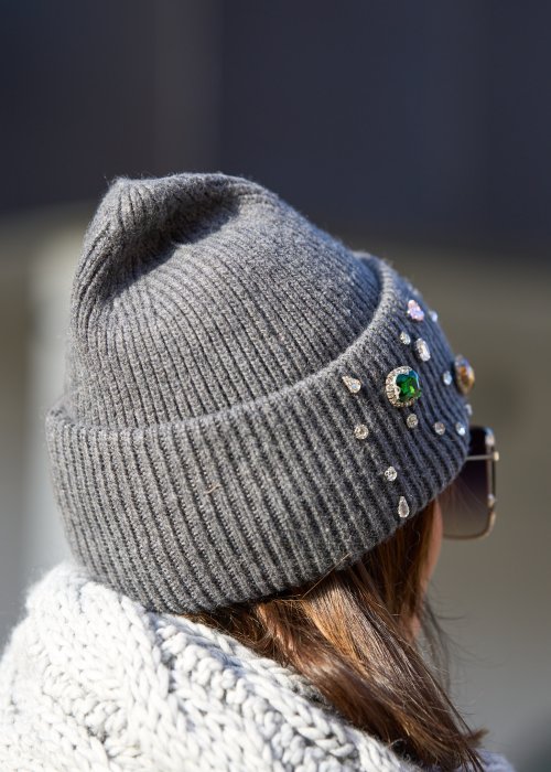 szarej czapce z dużymi kolorowymi kryształkami
