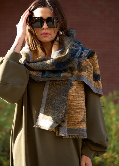 dużą szalikopłachtą we wzór liści w odcieniach złota i zieleni