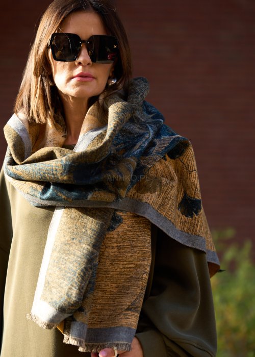 dużą szalikopłachtą we wzór liści w odcieniach złota i zieleni