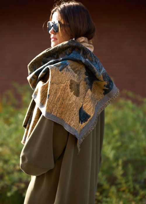 dużą szalikopłachtą we wzór liści w odcieniach złota i zieleni