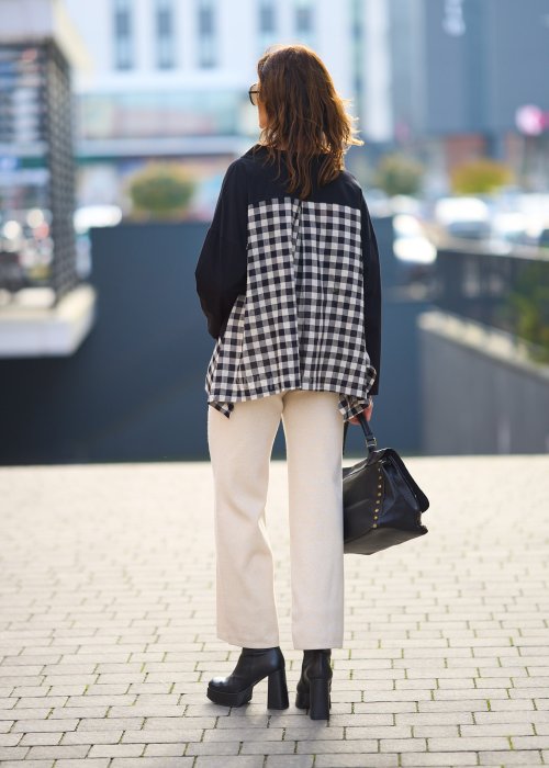 Stylowa czarna bluzka z kontrastowym, kraciastym wzorem na dole i rękawach.