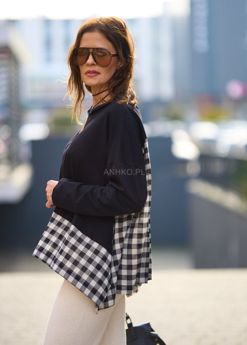 Stylowa czarna bluzka z kontrastowym, kraciastym wzorem na dole i rękawach.