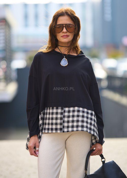 Stylowa czarna bluzka z kontrastowym, kraciastym wzorem na dole i rękawach.