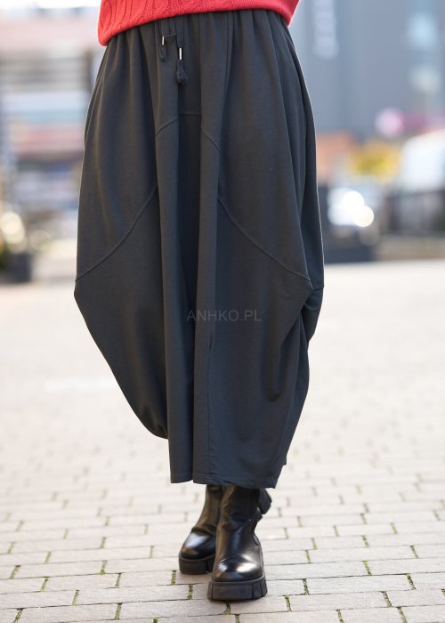 Antracytowa spódnica maxi typu bombka z elastycznym pasem i przeszyciami, zestawiona z czerwonym swetrem i czarnymi botkami w miejskiej stylizacji.