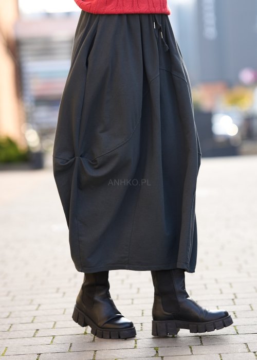 Antracytowa spódnica maxi typu bombka z elastycznym pasem i przeszyciami, zestawiona z czerwonym swetrem i czarnymi botkami w miejskiej stylizacji.