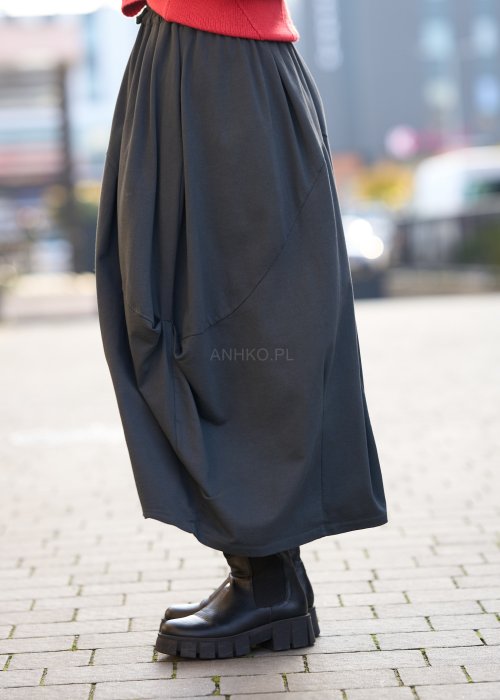 Antracytowa spódnica maxi typu bombka z elastycznym pasem i przeszyciami, zestawiona z czerwonym swetrem i czarnymi botkami w miejskiej stylizacji.