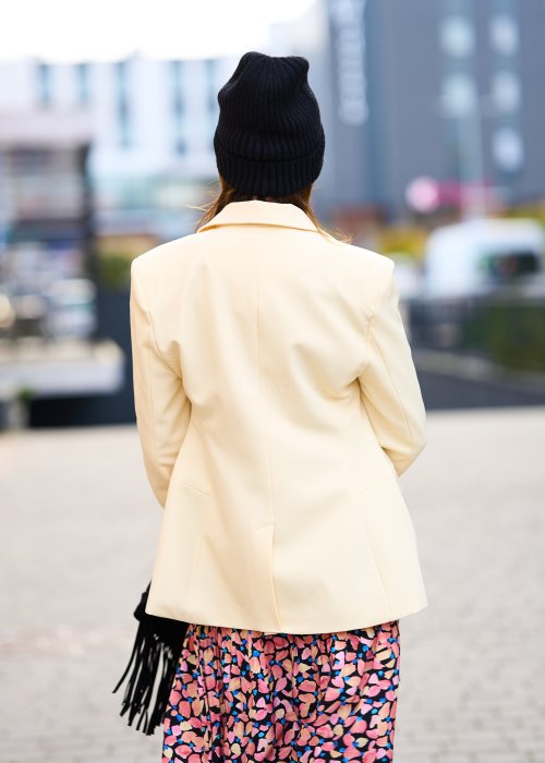 Marynarka ecru z gładkiej tkaniny, klasyczny kołnierz, jednorzędowe zapięcie i elegancki prosty fason