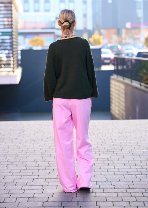 Różowe spodnie dresowe damskie z elastyczną talią i sznurkiem, o luźnym kroju i długich nogawkach, stylizowane w miejskim casualowym looku ze sneakersami.