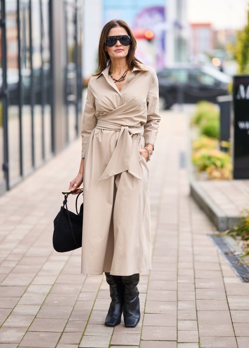 Damska beżowa sukienka midi z wiązaniem w talii i dekoltem V, zapinana na guziki do połowy. Model o luźnym kroju i eleganckiej, minimalistycznej formie.