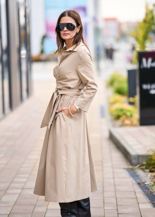 Damska beżowa sukienka midi z wiązaniem w talii i dekoltem V, zapinana na guziki do połowy. Model o luźnym kroju i eleganckiej, minimalistycznej formie.