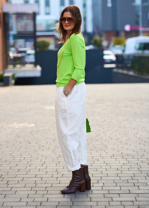 Kremowe spodnie z naturalnej tkaniny, luźna nogawka, elastyczny pas i swobodny fason w stylu boho