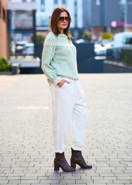 Kremowe spodnie z naturalnej tkaniny, luźna nogawka, elastyczny pas i swobodny fason w stylu boho