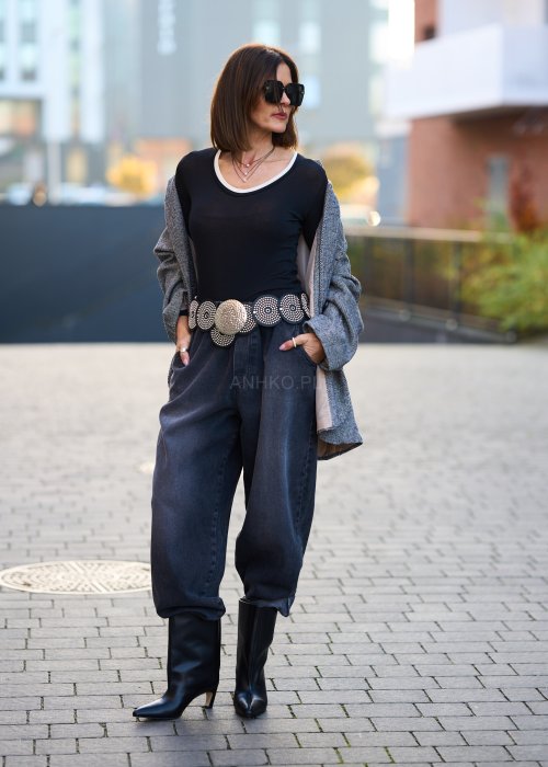 Antracytowe jeansy damskie o luźnym kroju z podwiniętymi nogawkami, stylizowane z czarnym topem i botkami na obcasie w miejskim looku.
