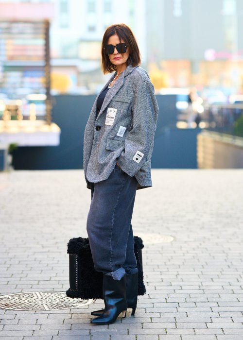 Antracytowe jeansy damskie o luźnym kroju z podwiniętymi nogawkami, stylizowane z czarnym topem i botkami na obcasie w miejskim looku.