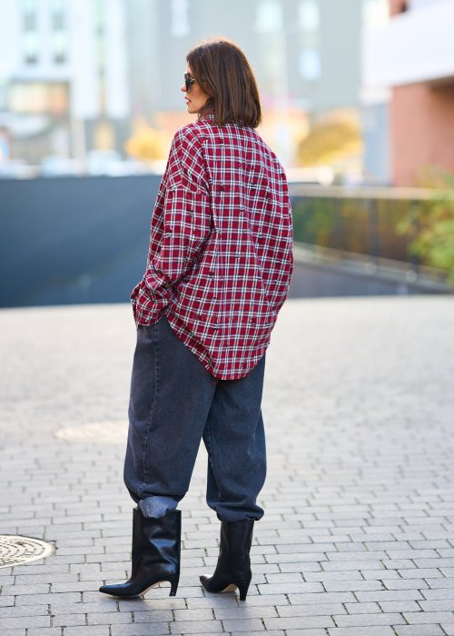 Antracytowe jeansy damskie o luźnym kroju z podwiniętymi nogawkami, stylizowane z czarnym topem i botkami na obcasie w miejskim looku.