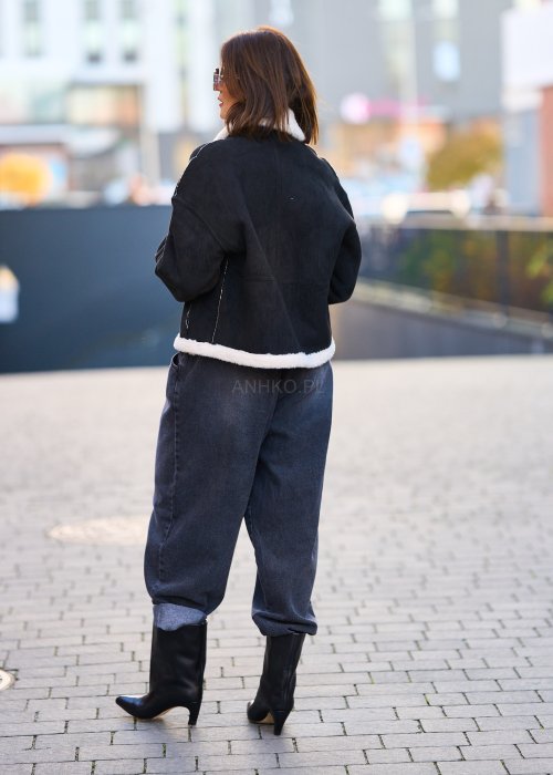 Antracytowe jeansy damskie o luźnym kroju z podwiniętymi nogawkami, stylizowane z czarnym topem i botkami na obcasie w miejskim looku.