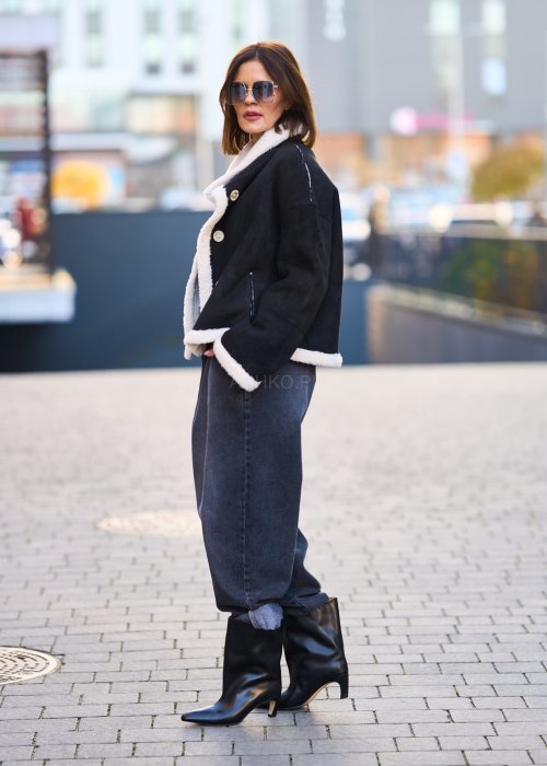 Antracytowe jeansy damskie o luźnym kroju z podwiniętymi nogawkami, stylizowane z czarnym topem i botkami na obcasie w miejskim looku.