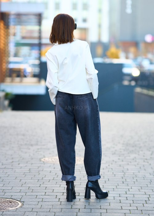 Antracytowe jeansy damskie o luźnym kroju z podwiniętymi nogawkami, stylizowane z czarnym topem i botkami na obcasie w miejskim looku.